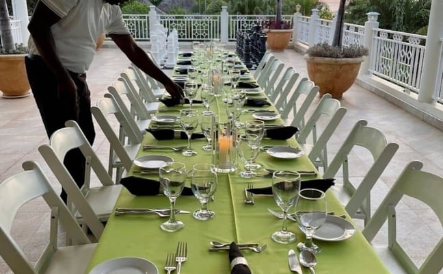 butler setting up table at Mais Oui Villa in Discovery Bay Jamaica for family vacation at a Jamaica family villa