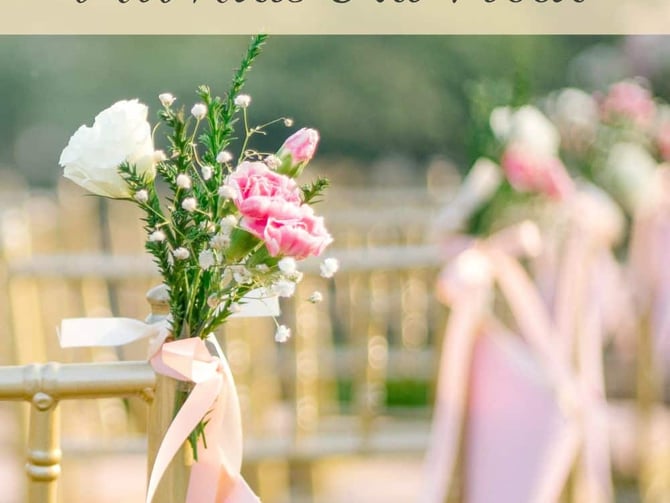 Wedding ceremony setup with pink and white flowers tied to gold chairs with pink ribbon
